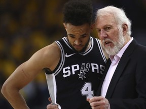 San Antonio Spurs coach Gregg Popovich, right, speaks with Derrick White during the second half in Game 1 of a first-round NBA basketball playoff series against the Golden State Warriors on Saturday, April 14, 2018, in Oakland, Calif.