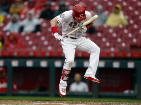 Cincinnati Reds' Scooter Gennett leaps out of the way of an inside pitch by St. Louis Cardinals starter Carlos Martinez during the first inning of a baseball game Sunday, April 15, 2018, in Cincinnati.