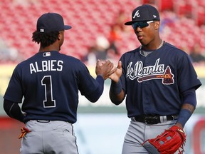 Atlanta Braves center fielder Ronald Acuna Jr., right, and second baseman Ozzie Albies (1) meet on the field as the Braves warmed up for a baseball game against the Cincinnati Reds, Wednesday, April 25, 2018, in Cincinnati.