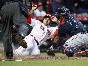 Cincinnati Reds' Adam Duvall (23) scores against Atlanta Braves catcher Carlos Perez, right, during the fifth inning of a baseball game Wednesday, April 25, 2018, in Cincinnati.