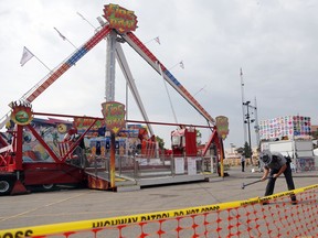 FILE - In this July 27, 2017 file photo, an Ohio State Highway Patrol trooper removes a ground spike in front of the Fire Ball ride at the Ohio State Fair, in Columbus, Ohio. Attorneys for the family of a teenager killed in a thrill ride accident at the Ohio State Fair and others left with life-changing injuries believe the state's inspectors missed obvious warning signs. But the attorneys won't include the state in any lawsuits or financial settlements because Ohio, like many other states, gives its carnival ride inspectors immunity from accusations of negligence.