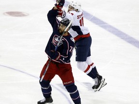 Columbus Blue Jackets forward Nick Foligno, left, catches the puck against Washington Capitals forward Brett Connolly during the first overtime period in Game 3 of an NHL first-round hockey playoff series in Columbus, Ohio, Tuesday, April 17, 2018. The Capitals won 3-2 in double overtime.