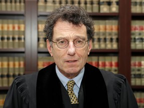 FILE – In this Jan. 11, 2018, file photo, Judge Dan Polster poses for a portrait in his office in Cleveland. Polster issued an order Wednesday, April 11, 2018, scheduling three Ohio trials for 2019 in local government lawsuits against the drug industry over prescription opioid painkillers, a shift from the federal judge's audacious plan to settle hundreds of such lawsuits.