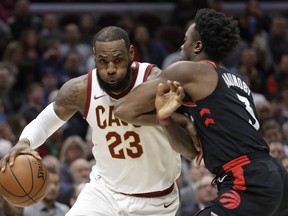 Cleveland Cavaliers' LeBron James, left, drives past Toronto Raptors' OG Anunoby during the first half of an NBA basketball game Tuesday, April 3, 2018, in Cleveland.