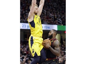 Cleveland Cavaliers' LeBron James, right, is stopped by Indiana Pacers' Domantas Sabonis, from Lithuania, in the first half of a first-round playoff series in an NBA basketball game, Sunday, April 15, 2018, in Cleveland.