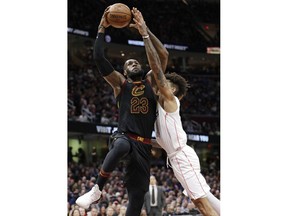 Cleveland Cavaliers' LeBron James, left, drives to the basket against Washington Wizards' Kelly Oubre Jr. in the first half of an NBA basketball game, Thursday, April 5, 2018, in Cleveland.