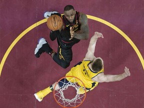 Cleveland Cavaliers' LeBron James, top, drives against Indiana Pacers' Domantas Sabonis, from Lithuania, in the first half of Game 1 of an NBA basketball first-round playoff series Sunday, April 15, 2018, in Cleveland.