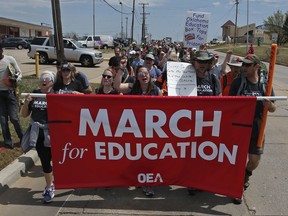 Demonstrators walk along NE 36th St. in the final leg of a 110 miles trip from Tulsa to the state Capitol as protests continue over school funding, in Oklahoma City, Tuesday, April 10, 2018.