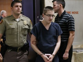 FILE - In this Feb. 23, 2016 file photo, Michael Bever, center, is led from a courtroom following a hearing in Tulsa, Okla. Bever, the younger of two brothers accused of fatally stabbing their parents and three siblings inside a suburban Oklahoma home is scheduled to go on trial Monday, April 16, 2018. Bever is charged in Tulsa district court with five counts of first-degree murder and one count of assault and battery with the intent to kill for his role in the July 2015 stabbings.