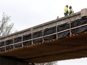 FILE - In this March 20, 2018, file photo, construction workers prepare for the teardown of a U.S. 75 bridge deck over Southwest Boulevard in Tulsa, Okla. In the Trump era, a popular $500 million transportation grant program is focused more on funding projects in rural areas that turned out for Trump. The result is more road and rail projects in red states like Idaho, North Dakota, and Oklahoma _ and fewer "greenways," "complete streets," and bike lanes.