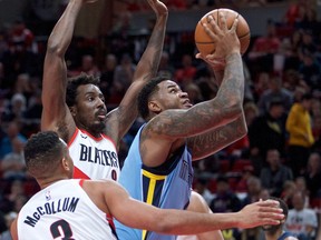 Memphis Grizzlies forward Jarell Martin, right, shoots in front of Portland Trail Blazers forward Al-Farouq Aminu, left rearl during the first half of an NBA basketball game in Portland, Ore., Sunday, April 1, 2018.