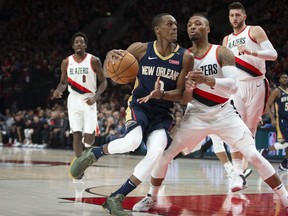 New Orleans Pelicans guard Rajon Rondo, front left, drives against Portland Trail Blazers guard Damian Lillard during the first half in Game 1 of an NBA basketball first-round playoff series Saturday, April 14, 2018, in Portland, Ore.