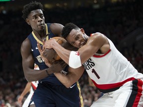 New Orleans Pelicans guard Jrue Holiday and Portland Trail Blazers forward Evan Turner vie for the ball during the first half in Game 1 of an NBA basketball first-round playoff series Saturday, April 14, 2018, in Portland, Ore.