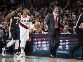 As New Orleans Pelicans guard Ian Clark and Portland Trail Blazers guard Damian Lillard listen, Blazers coach Terry Stotts questions an official during the first half in Game 1 of an NBA basketball first-round playoff series Saturday, April 14, 2018, in Portland, Ore.