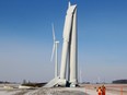 Workers erect a temporary fence around this industrial wind turbine on Friday, January 19, 2018, that buckled at the half-way point.