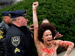 A protester is detained as Bill Cosby arrives for his sexual assault trial at the Montgomery County Courthouse, Monday, April 9, 2018, in Norristown, Pa.