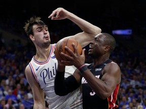 Miami Heat's Dwyane Wade, right, makes his move against Philadelphia 76ers' Dario Saric, left, of Croatia, during the first half in Game 1 of a first-round NBA basketball playoff series, Saturday, April 14, 2018, in Philadelphia.