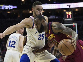 Cleveland Cavaliers' LeBron James, right, drives to the basket against Philadelphia 76ers' Ben Simmons, left, of Australia, during the first half of an NBA basketball game, Friday, April 6, 2018, in Philadelphia.