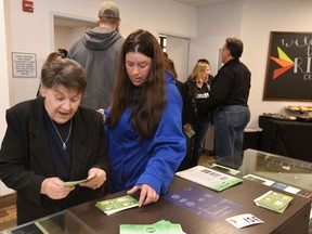 Diane Walters, left, and her caregiver Tasha Zirkle look over free literature during an open house in Erie, Pa., Monday, April 16, 2018, at the region's first medical marijuana dispensary that will be open April 18, for patients with state-issued medical marijuana identification cards.