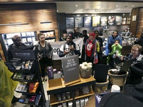 Demonstrators occupy the Starbucks that has become the center of protests Monday, April 16, 2018, in Philadelphia. Starbucks wants to add training for store managers on "unconscious bias," CEO Kevin Johnson said Monday, as activists held more protests at a Philadelphia store where two black men were arrested after employees said they were trespassing.
