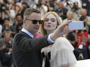 FILE - In this May 20, 2016 file photo, director Nicolas Winding Refn and actress Elle Fanning pose for a selfie photograph during a photo call for the film The Neon Demon at the 69th international film festival, Cannes, southern France. Cannes Film Festival organizers are banning red carpet selfies this year, calling them grotesque and ridiculous.