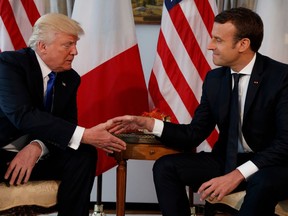 In this May 25, 2017 file photo, U.S. President Donald Trump shakes hands with French President Emmanuel Macron during a meeting at the U.S. Embassy in Brussels.
