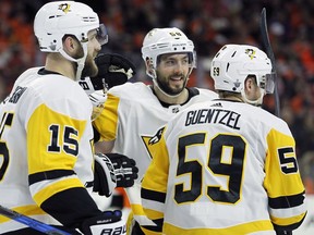 From left to right, Pittsburgh Penguins' Riley Sheahan, Kris Letang and Jake Guentzel celebrate Guentzel's goal during the third period in Game 6 of an NHL first-round hockey playoff series against the Philadelphia Flyers, Sunday, April 22, 2018, in Philadelphia.