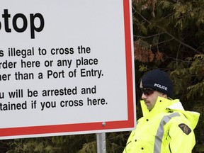 An RCMP officer stands guard at the border leading into Canada from the United States on Wednesday, April 18, 2018 near Champlain, NY.