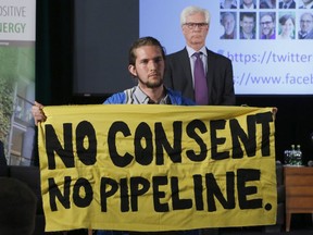 Trans Mountain Pipeline protester Gabriel D'astous interrupts a speech by Natural Resources Minister Jim Carr at the "Positive Energy" conference at the University of Ottawa on Monday, April 23, 2018.