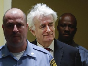 Former Bosnian Serb leader Radovan Karadzic, center, arrives to open his appeal at a U.N. court against his convictions on charges including genocide and crimes against humanity and his 40-year prison sentence in The Hague, Netherlands, Monday, April 23, 2018.