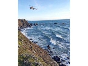 FILE - This March 27, 2018, file photo provided by the California Highway Patrol shows a helicopter hovering over steep coastal cliffs near Mendocino, Calif., where a vehicle, visible at lower right, plunged about 100 feet off a cliff along Highway 1, killing all passengers. The SUV carrying the Hart family, from Woodland, Wash., accelerated straight off the scenic California cliff and authorities said the deadly wreck may have been intentional. (California Highway Patrol via AP, File)