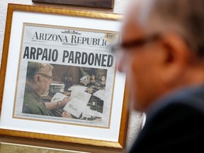 FILE - In this Jan. 10, 2018, file photo, a newspaper declaring the pardon of former Maricopa County Sheriff and U.S. Senate candidate Joe Arpaio hangs on the wall of his office in Fountain Hills, Ariz. An appeals court on Tuesday, April 17, 2018, ordered that a special prosecutor be appointed to defend a court ruling that dismissed the now-pardoned criminal case but didn't erase his criminal record.