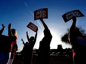 FILE - In this April 11, 2018, file photo, teachers at Humphrey Elementary school participate in a state-wide walk-in prior to classes in Chandler, Ariz. Arizona teachers began to vote Tuesday, April 17  on whether to walk off the job in their push for more funding for education.