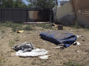 FILE--In this Monday, July 21, 2014, file photo, bedding, clothing and broken glass litter a homeless encampment in Albuquerque, N. M., where authorities say three teenagers fatally beat two homeless Navajo men in a crime so alarming it led to the creation of a city task force on Native American homelessness. The recent March 2018 killing in Albuquerque of another homeless man who also was from the Navajo Nation is again exposing the heightened dangers many say Native Americans coping with homelessness often face.