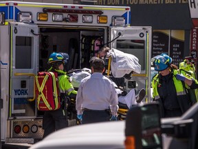 A injured person is put into the back of an ambulance in Toronto after a van mounted a sidewalk crashing into a number of pedestrians on Monday, April 23, 2018.