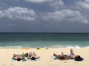 In this March 12, 2018, photo, foreign tourists sunbathe at a beach on Boracay, central Aklan province, Philippines.