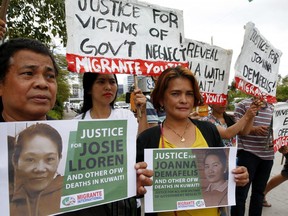 In this Wednesday, Feb. 21, 2018, file photo, protesters picket the Senate at the start of a probe into the death of an overseas worker in Kuwait in Pasay City, south of Manila, Philippines.