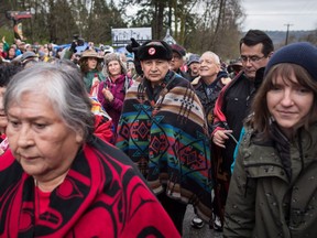 Grand Chief Stewart Phillip, centre right, President of the Union of B.C. Indian Chiefs, and Union of B.C. Indian Chiefs Vice President Chief Bob Chamberlin, back right, march with others opposed to the Kinder Morgan Trans Mountain pipeline extension at the company's property, in Burnaby, B.C., on Saturday April 7, 2018.