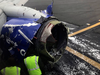 The engine on a Southwest Airlines plane is inspected as it sits on the runway at the Philadelphia International Airport after it made an emergency landing in Philadelphia, April 17, 2018.