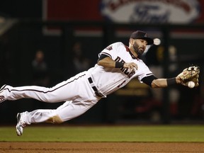 Arizona Diamondbacks third baseman Daniel Descalso knocks down a line drive hit by San Francisco Giants' Austin Jackson before throwing to second base to start a double play during the seventh inning of a baseball game Wednesday, April 18, 2018, in Phoenix.