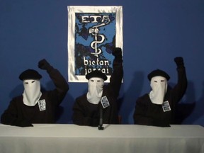 FILE - In this file image made from video provided on Oct. 20, 2011, masked members of the Basque separatist group ETA raise their fists in unison following a news conference at an undisclosed location. In a statement published on Friday April 20, 2018, the Basque militant group ETA says it is sorry for the pain that its armed campaign for Basque independence caused, and vows not to fall back into violence.  (Gara via AP, File)