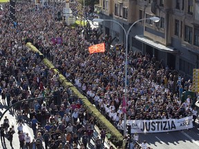 In this photo taken on Saturday April 14, 2018, tens of thousands of people march in Pamplona, the capital of the province where Alsasua is located, protesting the terrorism charges brought against eight defendants for a fight in a bar. A trial over the beating of two police officers and their girlfriends two years ago in a bar in the small town of Alsasua, northern Spain opened Monday April 16, 2018 surrounded by controversy because of the terrorism charges brought against the eight defendants. Banner reads ' Justice'.