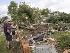 Residents survey the damage from a catagory one tornado, Wednesday, August 23, 2017 in Lachute, Que., northwest of Montreal. A cluster of tornadoes that knocked down trees and tore the roof off a home in southern Quebec last June was one of the largest ever recorded in Canada, according to new research from Western University that suggests the extreme storms are more common in the country than previously thought.