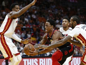 Toronto Raptors guard DeMar DeRozan drives to the basket against the Heat's Hassan Whiteside, left, Rodney McGruder, rear, and James Johnson during their game Wednesday night in Miami.