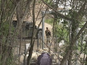 In this April 10, 2018 frame from video, a National Guard troop watches over Rio Grande River on the border in Roma, Texas. The deployment of National Guard members to the U.S.-Mexico border at President Donald Trump's request was underway Tuesday with a gradual ramp-up of troops under orders to help curb illegal immigration.