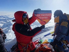 In this May 2017 photo provided by Lhakpa Sherpa, Sherpa displays a flag from West Hartford, Conn., on the summit of Mount Everest in Nepal. Once a year, Sherpa heads back to her native Nepal to try and break her own record for successful summits of Mount Everest by a woman.