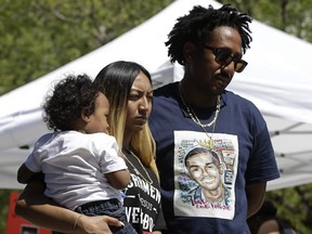 Salena Manni, the fiancee of police shooting victim Stephon Clark, holds the couple's son, Aiden as she and Clark's uncle, Curtis Gordon attend a rally aimed at ensuring Clark's memory and calling for police reform, Saturday, March 31, 2018, in Sacramento, Calif.