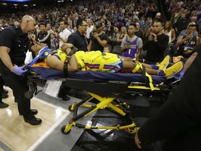 Golden State Warriors guard Patrick McCaw is taken off the court on a stretcher after falling hard to the floor late in the third quarter following a Flagrant 1 foul by Sacramento Kings's Vince Carter in an NBA basketball game Saturday, March 31, 2018, in Sacramento, Calif. The Warriors won 112-96.