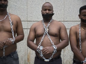 African migrants wear chains to represent slavery, during a demonstration in Tel Aviv, Israel, Tuesday, April 3, 2018.  Israel announced a deal with the U.N. on Monday to resettle African migrants in Western nations, but hours later put the agreement on hold.