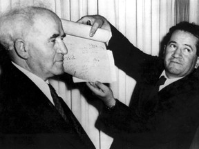 FILE - In this May 14, 1948 file photo, an official shows the signed document which proclaims the establishment of the new Jewish state of Israel declared by Prime Minister David Ben-Gurion in Tel Aviv, Israel. As Israel marks the 70th anniversary of statehood starting at sundown Wednesday, April 18, 2018, satisfaction over its successes and accomplishments share the stage with a grim disquiet over the never-ending conflict with the Palestinians, internal divisions and an uncertain place in a hostile region.